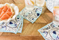 Cocktails napkins on table 
Our darling set of 4 cocktail napkins with hand painted features hand painted lend a sophisticated air and coastal component to any home. 
These soft linen napkins are artfully destined to add just the right touch to your next gathering.