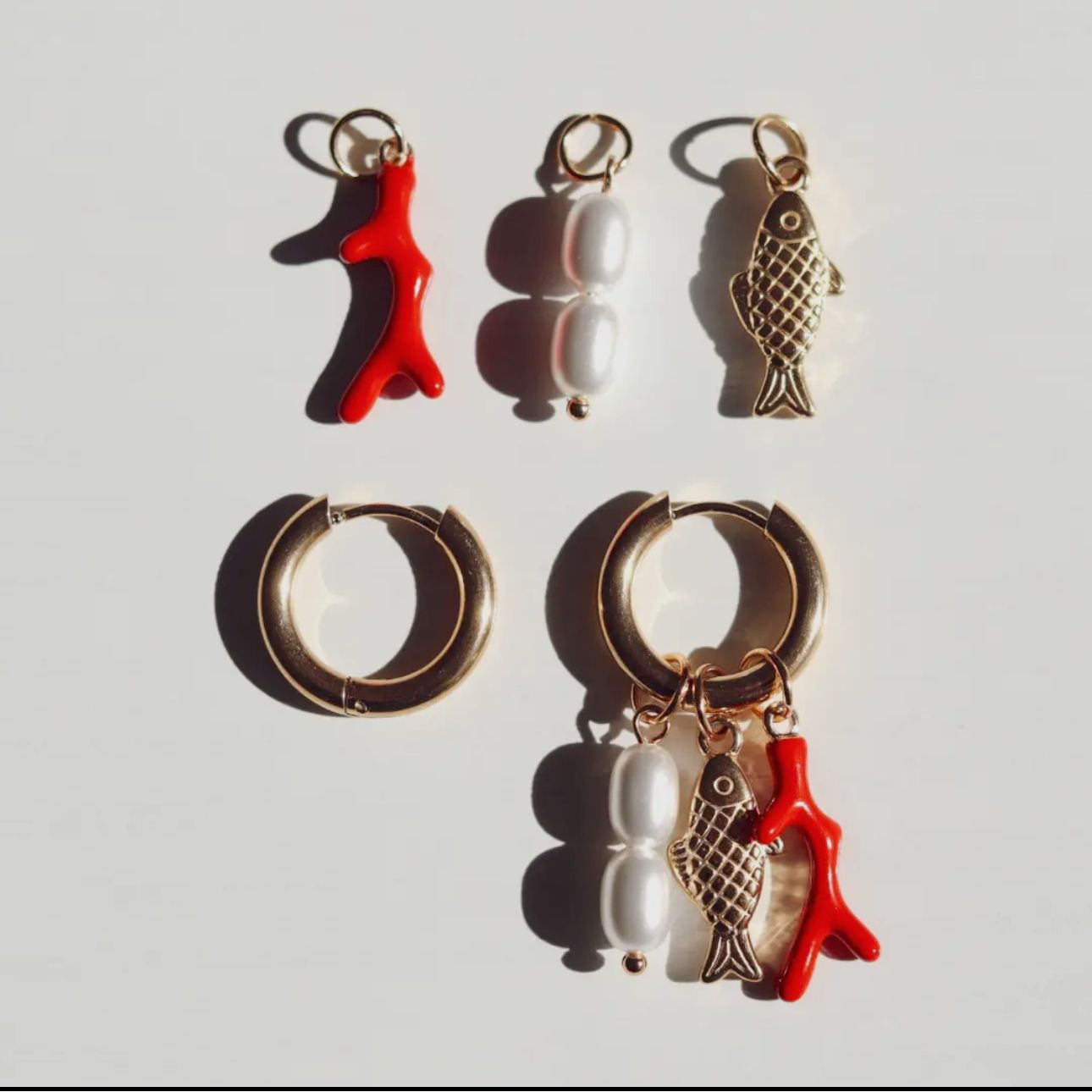 Gold plated hoop water proof fish shaped earrings with orange coral and pearls. Each charm can be worn together as shown or separately on the hoop