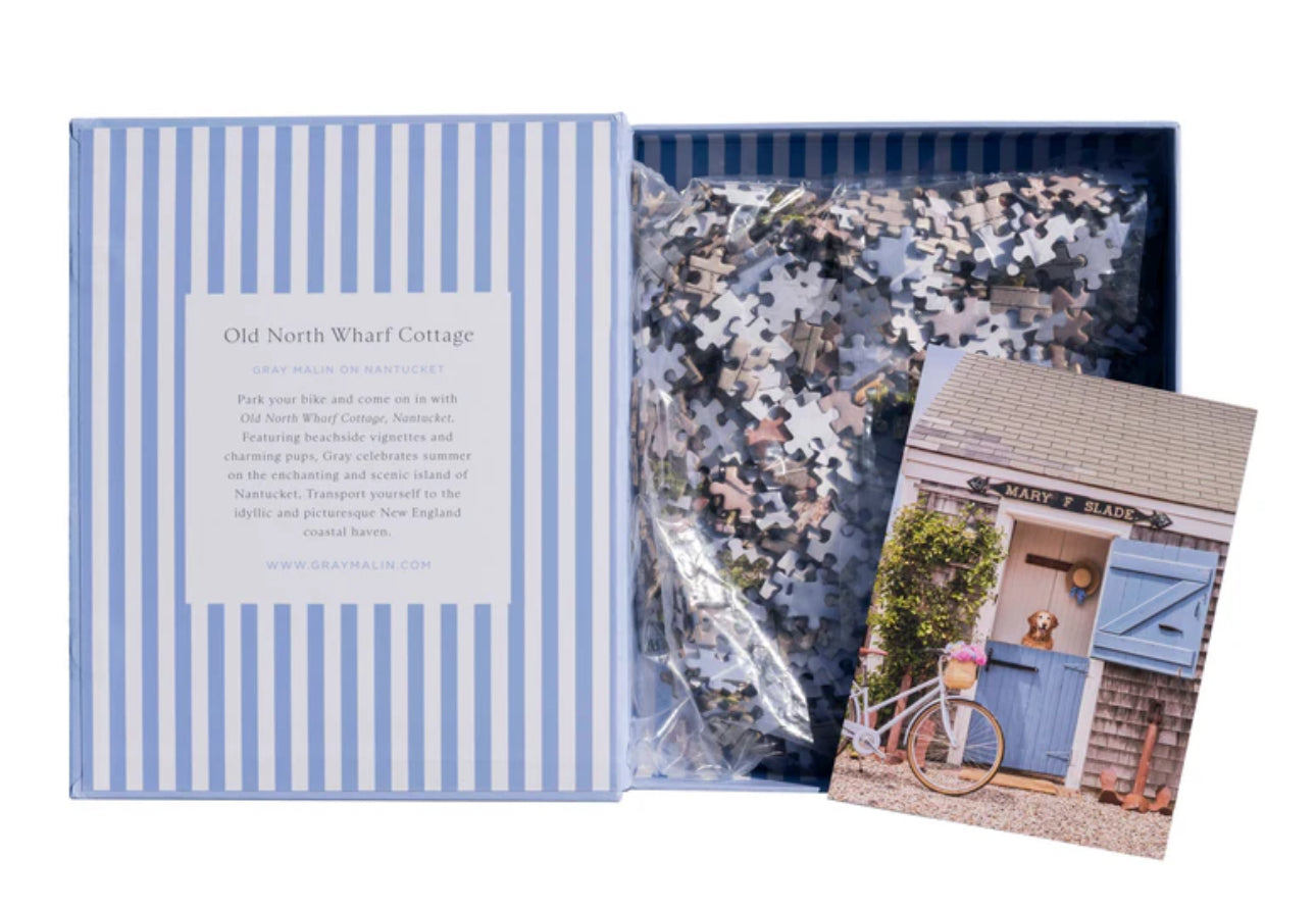 Showing puzzle book open with pieces
erfect for puzzle and fine art photography enthusiasts alike, Gray Malin Nantucket 1000 Piece Book Box Puzzle features "Old North Wharf Cottage, Nantucket" from Gray’s best-selling collection, 1000 pieces