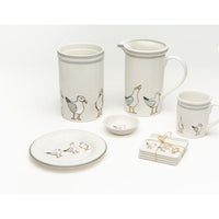 Bring the beach but not the sand into the kitchen as you gather with friends with this fun  set.
White earthenware with seagulls around the bottom. Pitcher, crock, fish, candle and coasters shown
