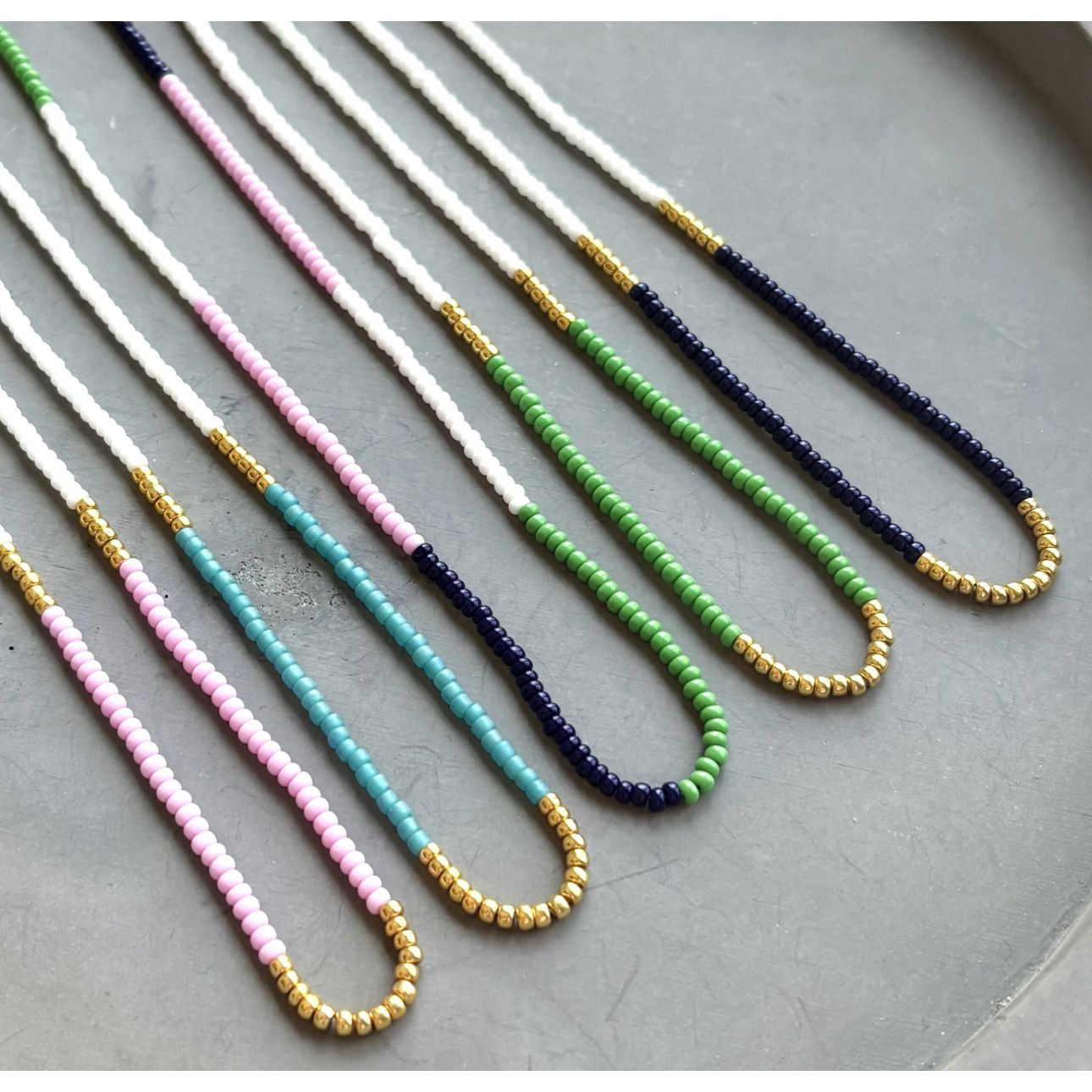 Bright, bold, and full of personality—these multicolor seed bead necklaces are made to stand out. With vivid green, turquoise, and deep navy tones, these handmade pieces bring a splash of joy to any outfit. Whether you're heading to a music festival, beach day, or brunch with friends, this design adds a playful pop of color that totally vibes.
 
Details:
•Vibrant green, lilac, turquoise, and navy seed beads
•Lightweight and comfortable
•Gold filled spring ring clasp 
 
Each piece is handmade, giving it a o