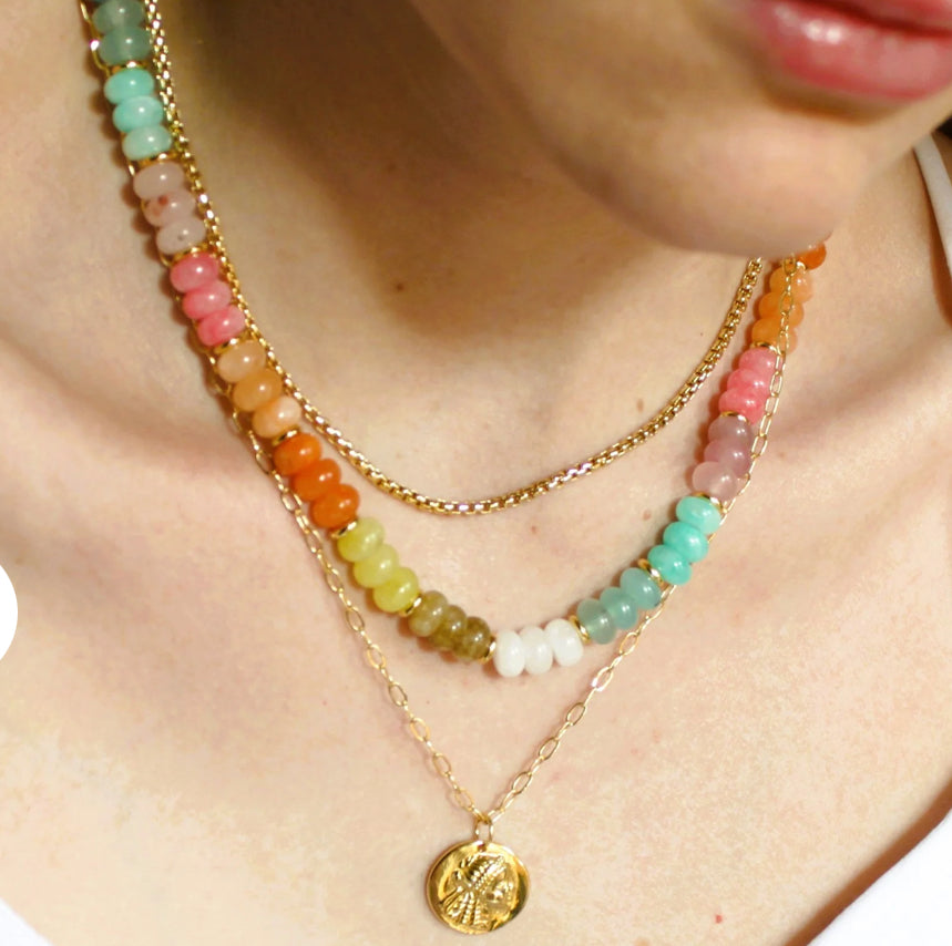 Necklace on women’s neck Gorgeous, natural dyed multi colored jade jade, 5x8mm beads - turquoise, white, yellow, pink, orange, light brown beads 
•Adorned with 14kt gold plated accents
•Beaded by hand just for you
Water friendly
18”
Made in USA
Handmade