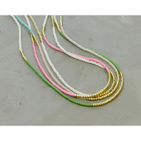 Our  necklace is handcrafted with a touch of gold in a minimalist style.   
•Seed beads in your choice of color combination 
•Hand strung in a modern pattern
•14kt Gold-Filled beads & spring clasp
•16 or 18 inch in length with an optional 2 inch extender
