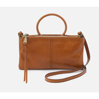 Inspired by our best-selling Sable wristlet,
this crossbody has the signature round
handle you know and love and a removable
strap for two looks in one.  Shown in truffle