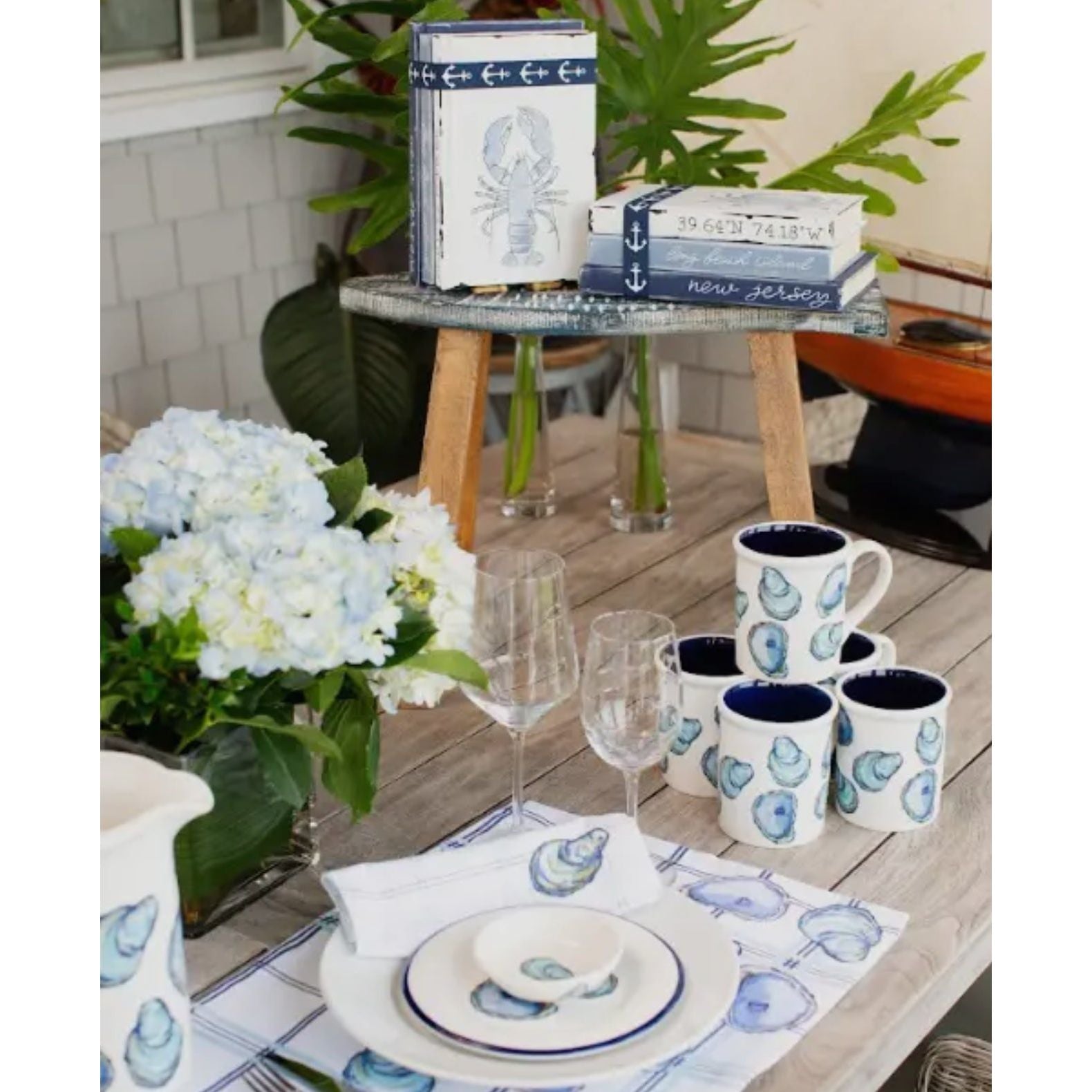 No shuck needed for this coastal oyster see.  White base with purple and blue painted  oysters.  Whole collection shown. Croc, pitcher, coaster, mug, tasting dishes shown on a set table