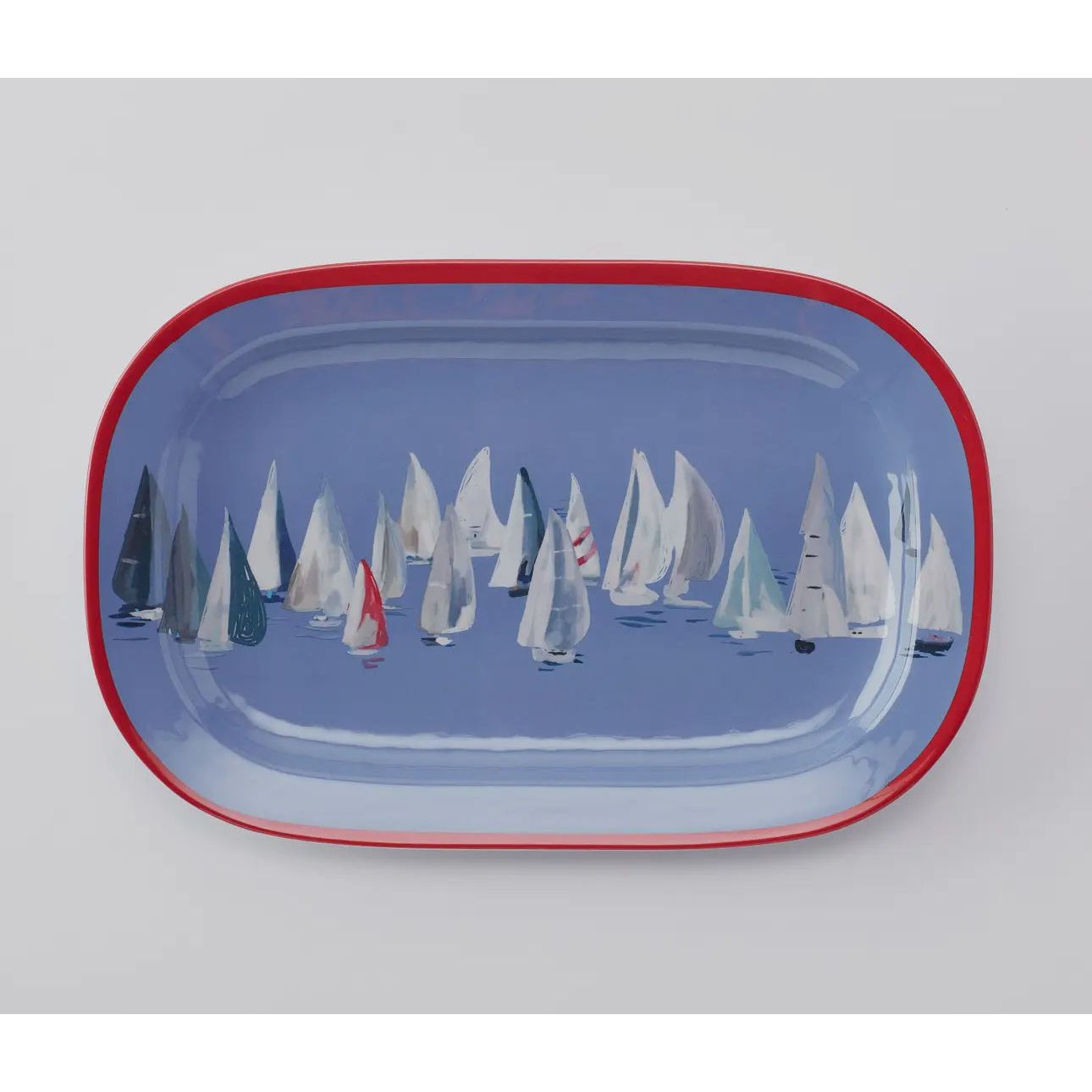 Set sail and a pop of color to your coastal table with the Race Day collection.   This melamine collection is great for indoor or outdoor entertaining in your coastal home.  This platter has a red rim pop with the interior being blue decorated with sailboats.
