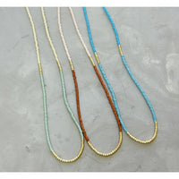 Our  necklace is handcrafted with a touch of gold in a minimalist style.   
•Seed beads in your choice of color combination 
•Hand strung in a modern pattern
•14kt Gold-Filled beads & spring clasp
•16 or 18 inch in length with an optional 2 inch extender