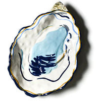 CURATE COASTAL VIBES FOR ANY PARTY.  OUR HAND PAINTED OYSTER DISH IS SURE TO BE THE TALK OF THE PARTY!  BEAUTIFULLY SHAPED TO RESEMBLE A SHUCKED OYSTER, THIS BEAUTIFULLY  DESIGNED DISH IS HAND PAINED IN A BEACH PALETTE OF BLUES AND GOLDS TO RESEMBLE A REAL SHUCKED OYSTER. 
EMBRACE  THE STYLE OF SEASIDE LIVING.
DISHWASHER SAFE AND MICROWAVE SAFE ON LOW HEAT 
CERAMIC