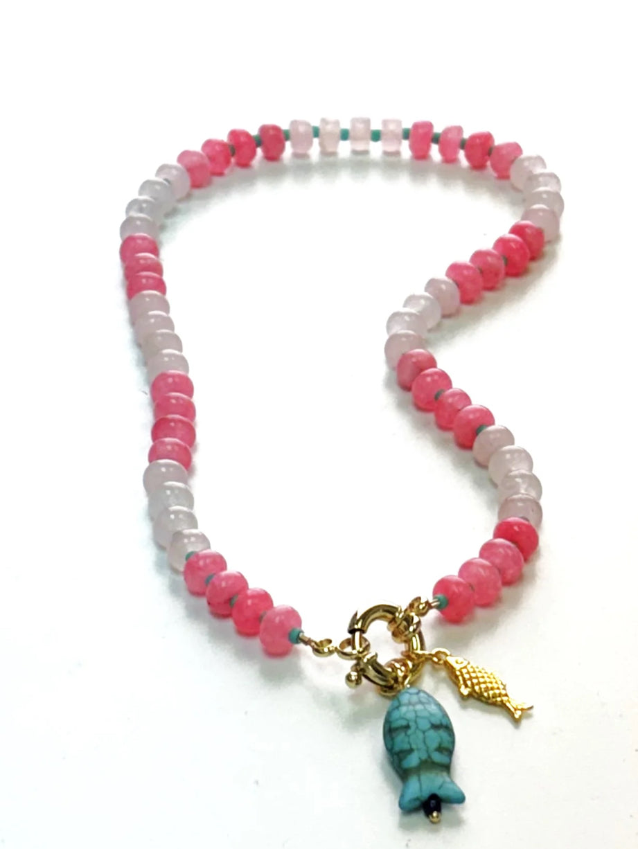 Add a splash of charm to your look with this playful beaded necklace, featuring alternating shades of soft pink and bold rose beads. Centered with a unique turquoise fish charm and a delicate gold fish pendant, this piece brings a whimsical, coastal-inspired flair to your outift 
16 or 18”



•Gorgeous, natural dyed jade, 5x8mm & adorned with glass seed bead accents 
•Gold Filled sailor clasp with a gold plated & turquoise