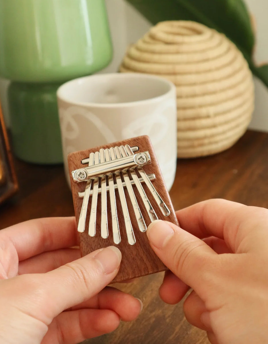 Heard in music around the world, the kalimba creates an unmistakable and ethereal sound. Our pocket-sized version has a sapele wood sound board and 8 steel keys for the best playing experience. Includes sheet music, tuning instructions and a guide. Tune before using.
Design: KDT
Materials: sapele wood, steel
Packaging: color box
Dimensions: 2.75" x 2" x 1" / 7 x 5,3 x 2,7 cm