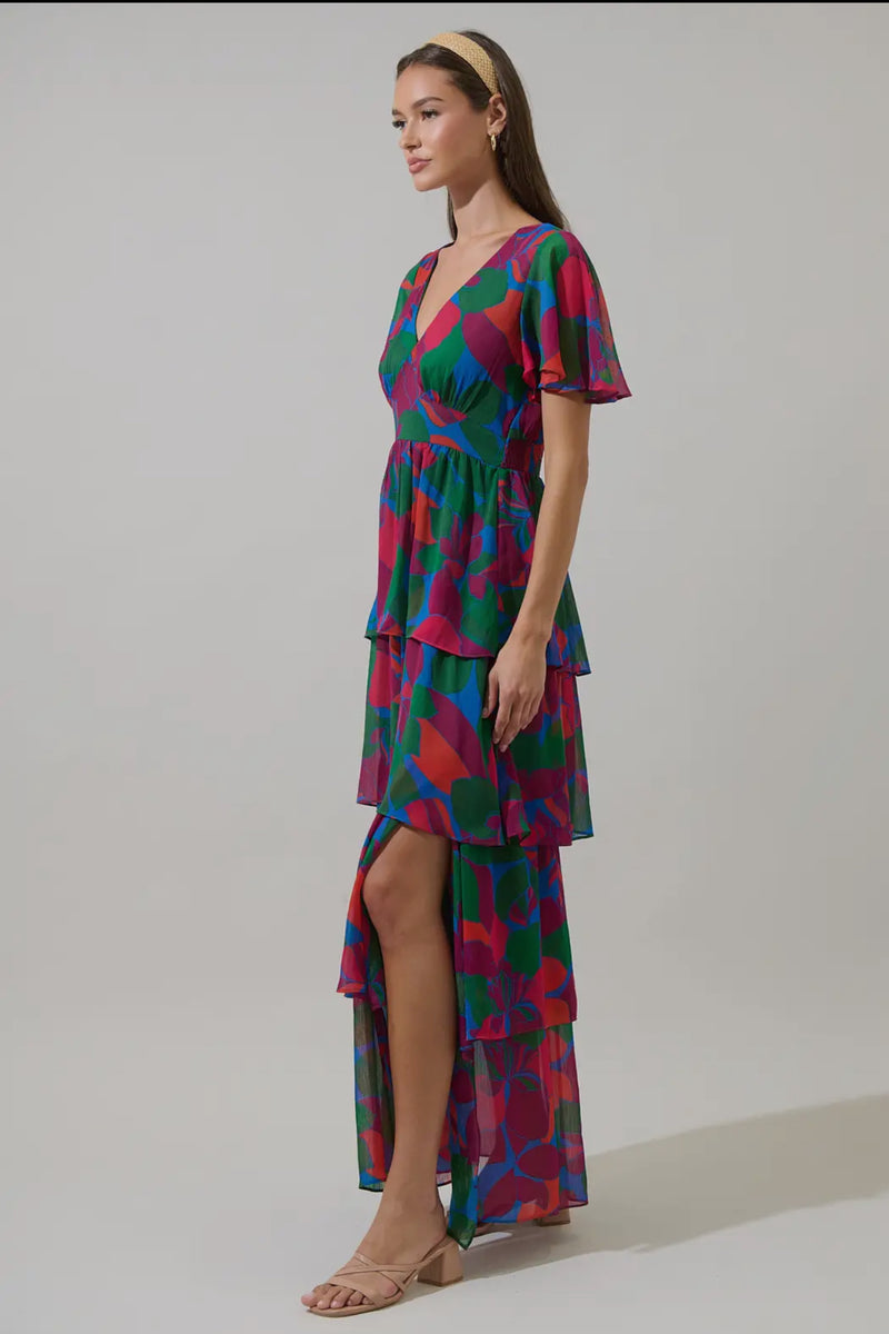 Keep it cute and pretty in the Kaeli Floral Amabel Tiered Maxi Dress. This floral-patterned maxi features a deep v-neck, short sleeves, and a tiered design with a smocked back for a flattering silhouette. Style it with block heels and a delicate clutch for a polished finish.

- Maxi
- Floral
- Deep V-neck
- Tiered
- Color: Magenta Blue Green

Size + Fit
- Model is 5'9" and wearing size XS
- Measurements taken from size S
- Chest: 19"
- Length: 58 1/4"

Fabric

Self: 100% Polyester, Lining: 97% Polyester 3% 