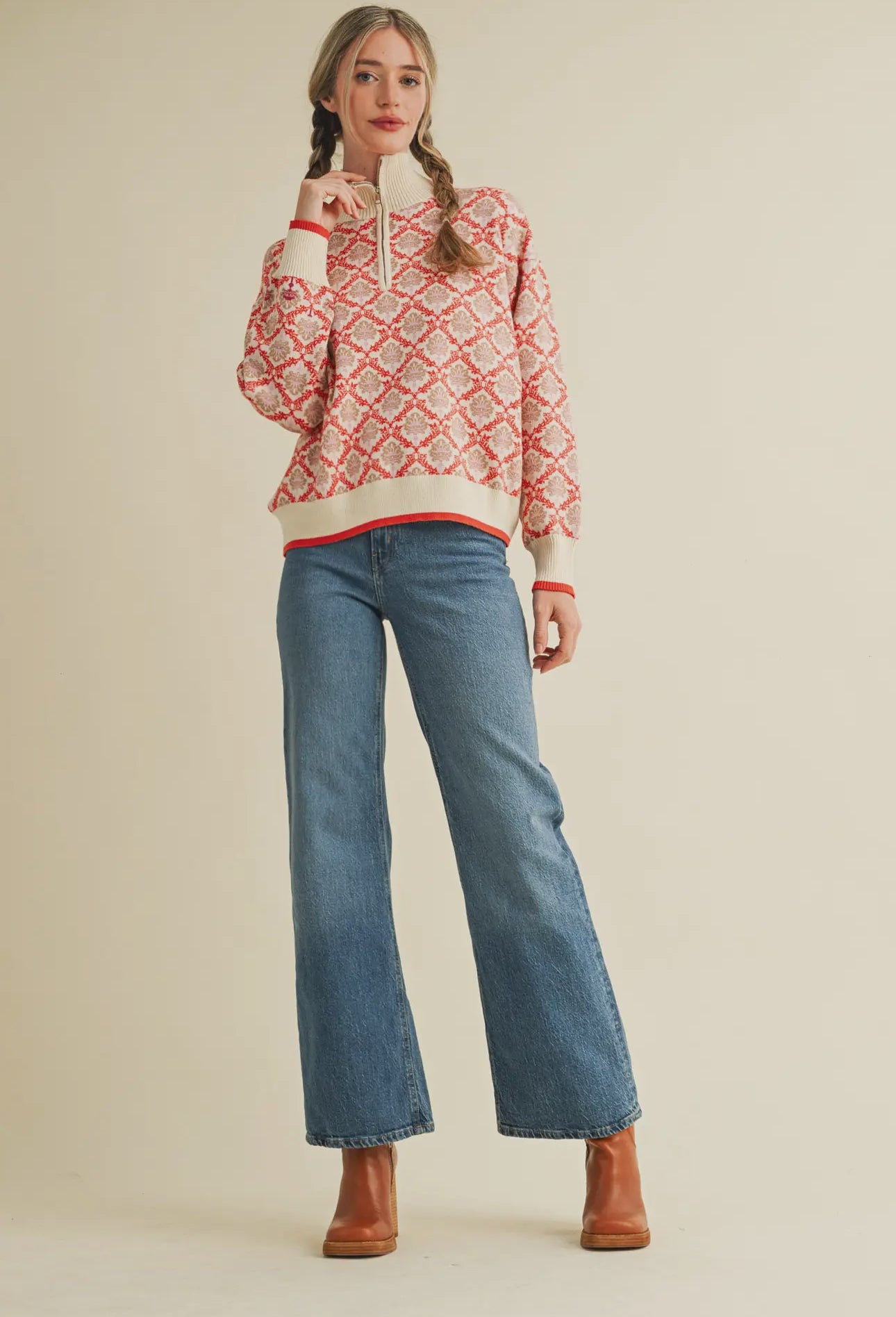 Sweater shown on model paired with neon boots and denim pants 