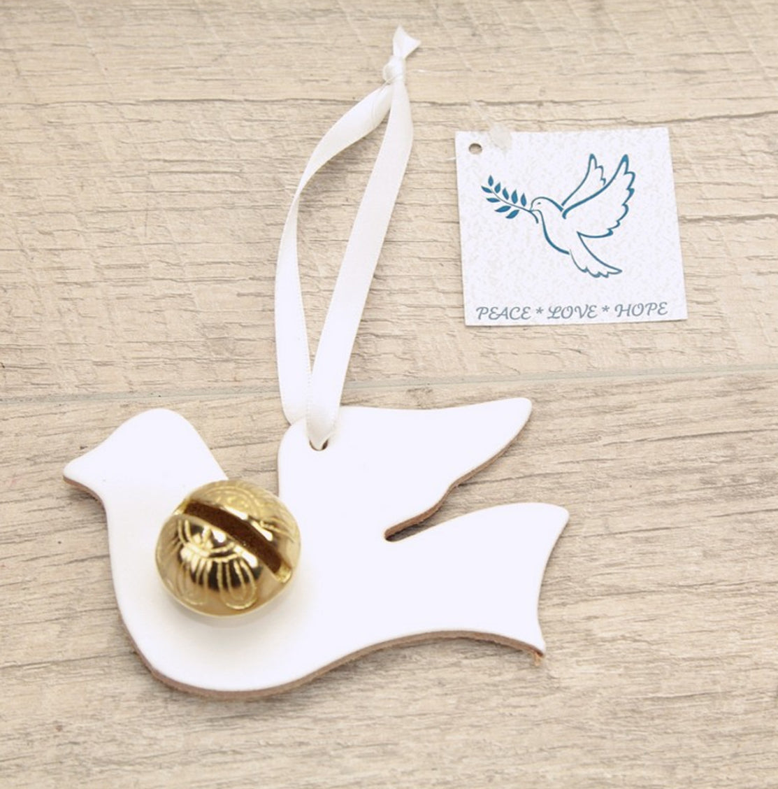 These lovely Dove keepsake bells make a perfect small gift. The Dove has a white ribbon and can be hung up in a special place as a reminder of the time shared with you. Doves are a sign of Peace, Love and Hope. They are about 4" wide and 3" tall. These are made in white leather and your choice of a brass or silver (Nickle plated) bell. 
