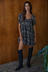 This mini dress brings a touch of garden party charm to any occasion. Picture it twirling at a summer picnic, paired with woven sandals and a sunhat. The lace trim and back smocking add a sweet, vintage-inspired touch, while the floral print keeps it light and playful. It's the kind of dress that invites compliments and carefree moments.

