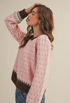 The warm pink and brown hies in this weather are perfect for getting cozy this winter. It also makes a great transition piece. The round neckline in contrasting colors adds to the details of this sweater.  