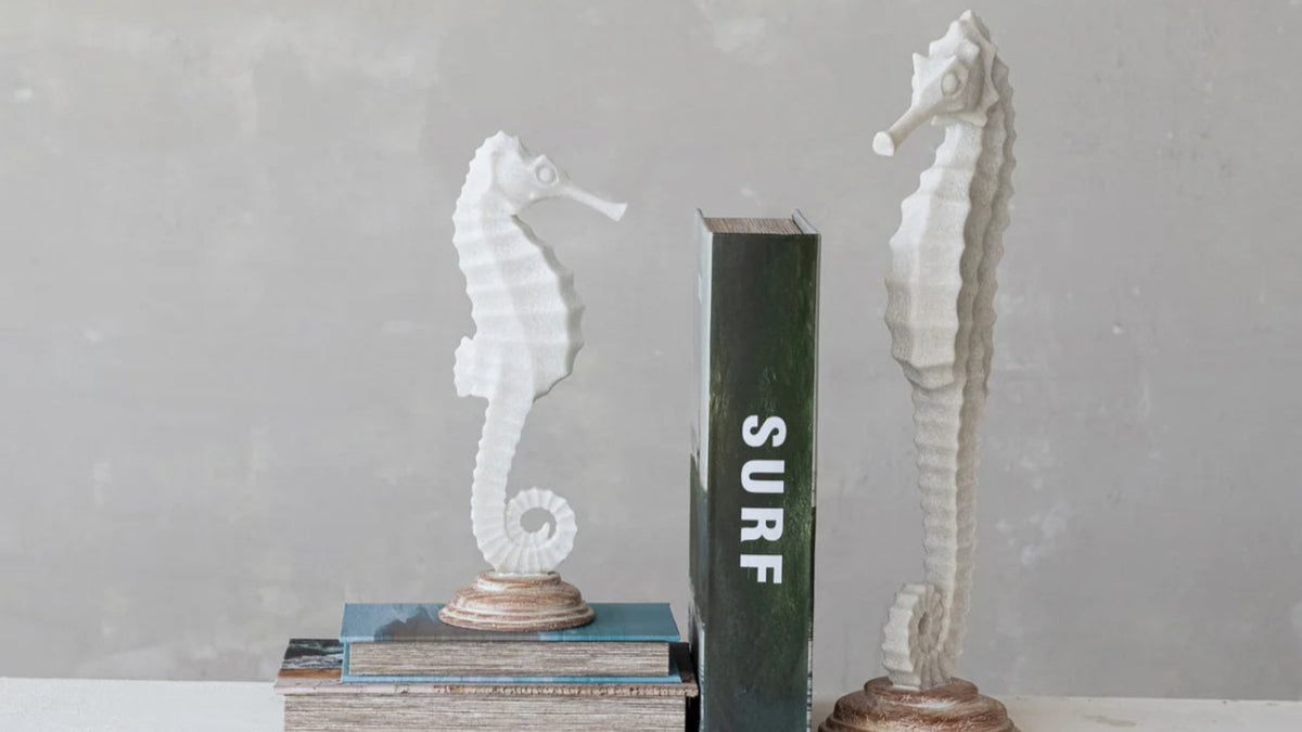 Showing both sides a of seahorse state as book ends 

Coastal elegance meets rustic home decor. Sand finished resin seahorses statue on wood base. 12.5” tall large 18” tall