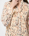 The Leithia Wispy Chiffon Neck Tie Top brings a modern boho feel to your fall lineup. Printed with an autumn-inspired floral on a cream base, it features an airy chiffon silhouette and an attached neck tie you can style your way—bowed, knotted, or left loose. Just add denim or suede and you’re set.

Top
Fabric: airy, lightweight, flowy, floral print, cream + brown
V-neckline
Self tie attached at neck
Long sleeve with flared cuffs
Our model is 5ft7.5" and wears a Size S