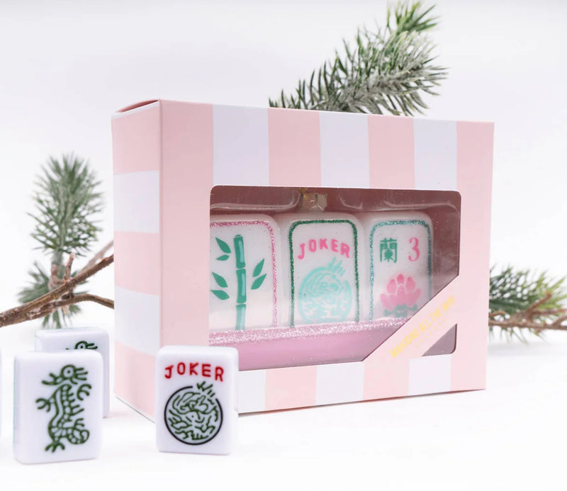Display your love for mahjong during the holidays with our stunning Mahjong Tile Glass Ornament. We've paid careful attention to detail, crafted from hand-painted imported glass and designed here in the USA. 

 4.5” x 1.5" x 2.5" Glass Hand Painted Boxed for easy gifting! All ornaments come ready to hang with metallic string attached.