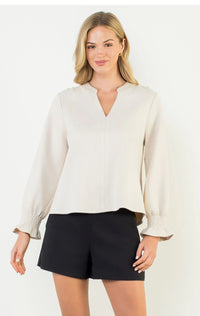Long sleeve with elastic at the wrist and slight ruffle. V neck