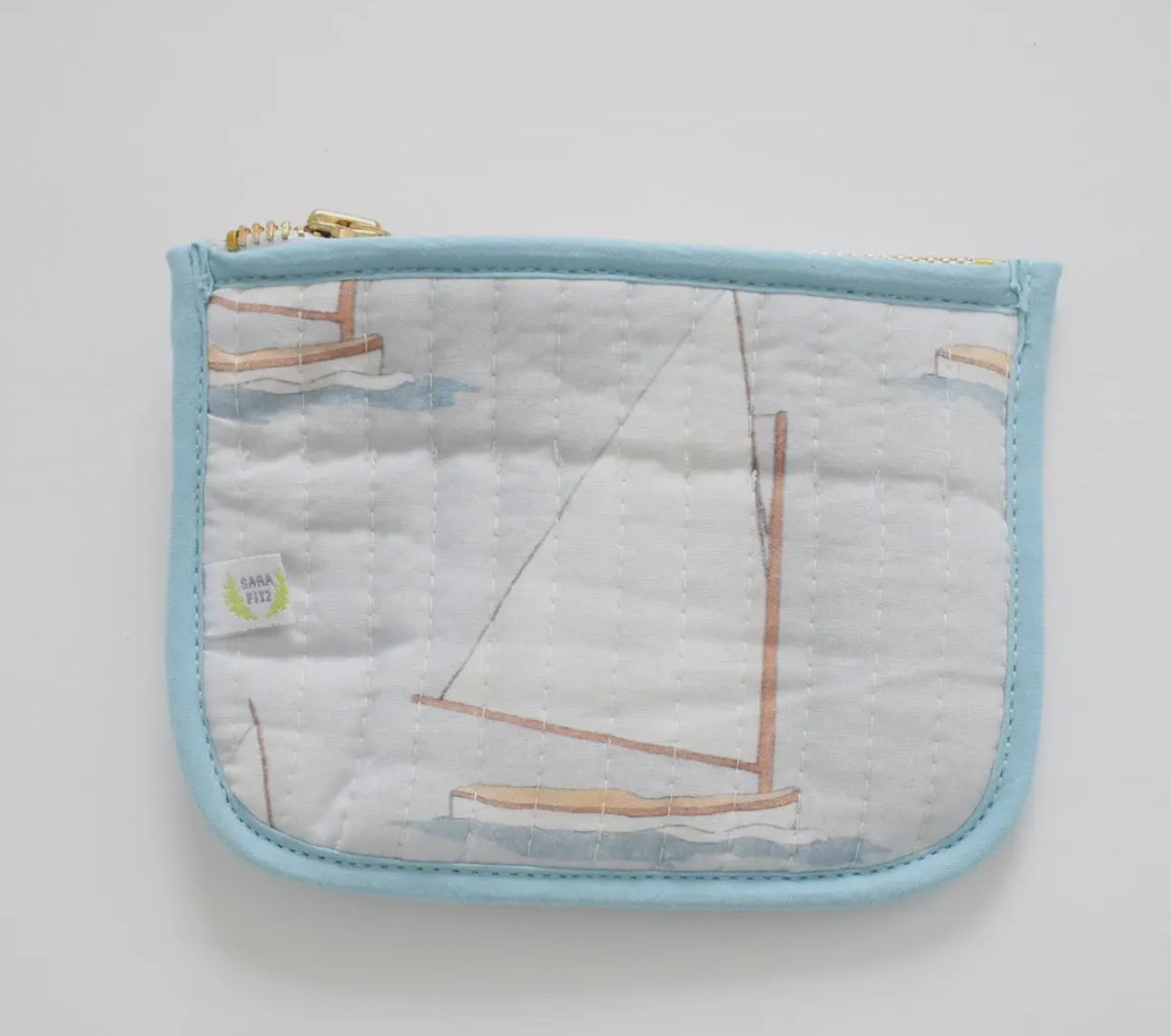 Gah! These little nuggets are the most adorable addition to our bag line! Perfect to hold cards and cash... throw them in any of our other bags! Sailboat shown 

100 percent cotton
Quilted texture 
5.5 inches long | 4 inches high | < 2 inches deep
Zip closure
Mild hand-wash cold, hang dry and warm iron
Made with great care in India
Due to the nature of the printing, you may notice minor imperfections in the fabric.