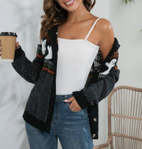 This adorable polka dot ghost cardigan is perfect for Halloween. 

White ghosts  around upper middle with black and white polka dots all over and white and orange lines above and below ghosts. 