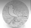 Showing seagull coaster on rock with waves etched in background 