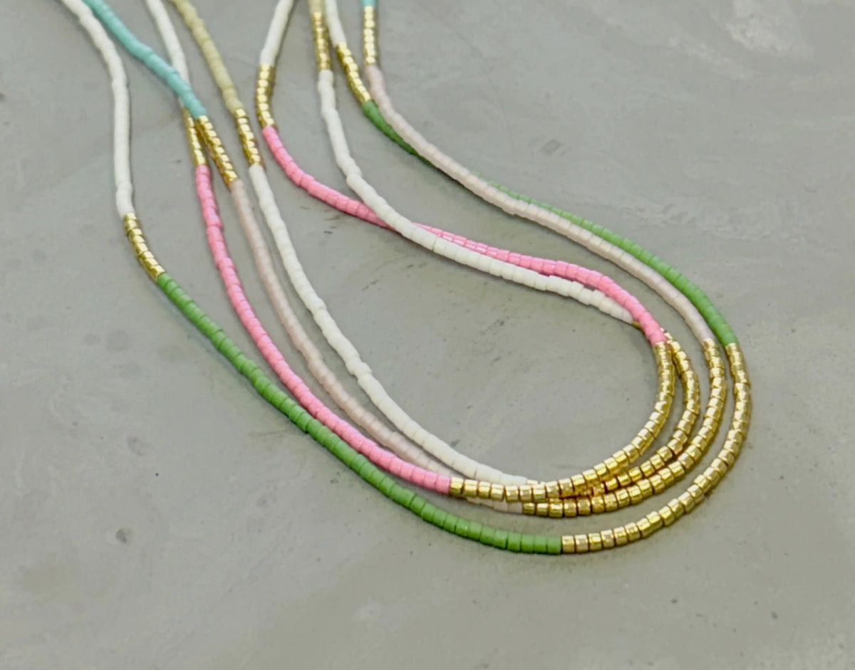Our  necklace is handcrafted with a touch of gold in a minimalist style.   

•Seed beads in your choice of color combination 
•Hand strung in a modern pattern
•14kt Gold-Filled beads & spring clasp

•16 or 18 inch in length with an optional 2 inch extender 