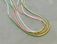 Our  necklace is handcrafted with a touch of gold in a minimalist style.   

•Seed beads in your choice of color combination 
•Hand strung in a modern pattern
•14kt Gold-Filled beads & spring clasp

•16 or 18 inch in length with an optional 2 inch extender 