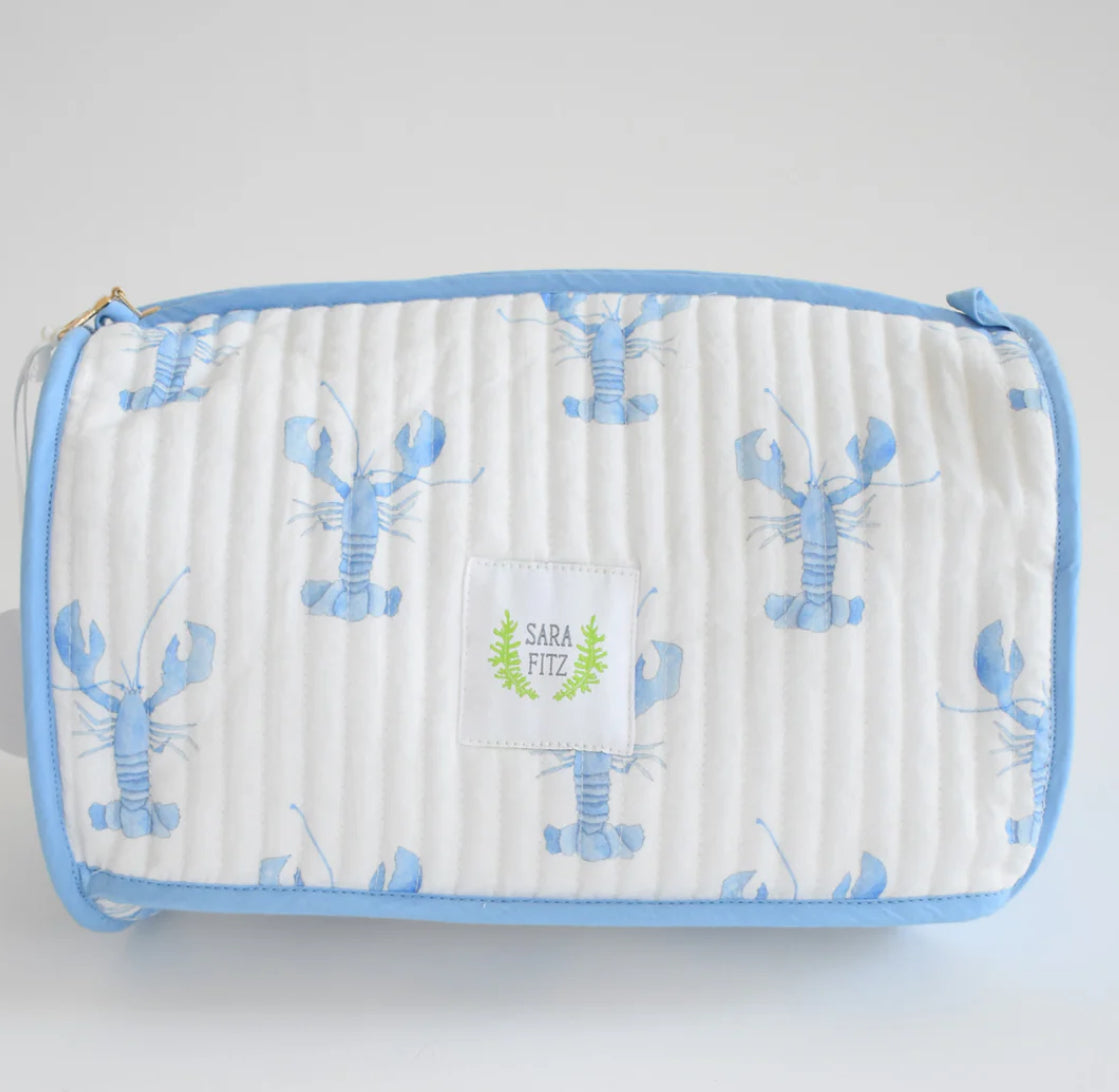 The most adorable bag to keep your toiletries tidy at home or on the go!
Showing lobster pattern 

Pair with the matching duffle, purse and coin purse for a full set. 
100 percent cotton
Quilted texture 
11 inches long | 6.5 inches high | 7 inches deep
Includes interior dual pocket
Mild hand-wash cold, hang dry and warm iron
Made with great care in India
Due to the nature of the printing, you may notice minor imperfections in the fabric.