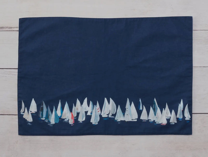 Dark blue side shown.  These 100% cotton placemats are reversible. The front side has sailboats all over and the reverse is a dark blue with a line of sailboats. 