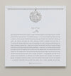 Silver necklace shown on card with saying 