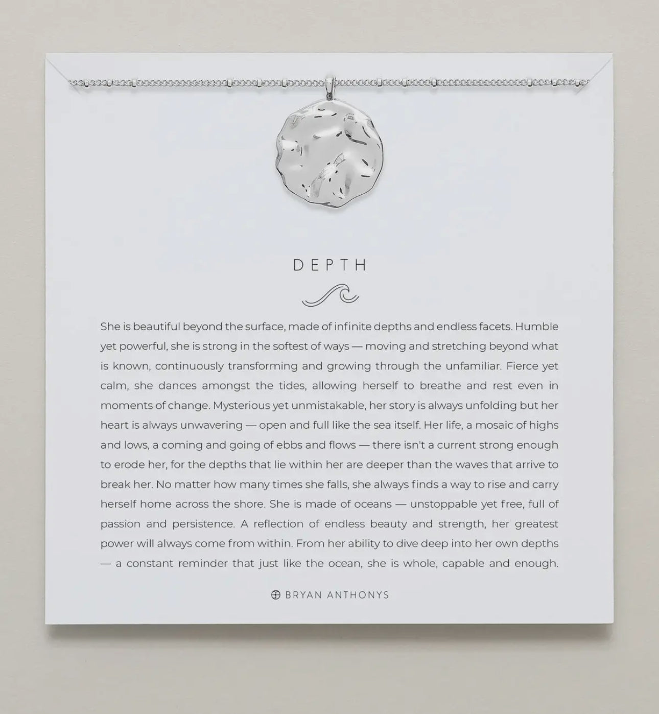 Silver necklace shown on card with saying 