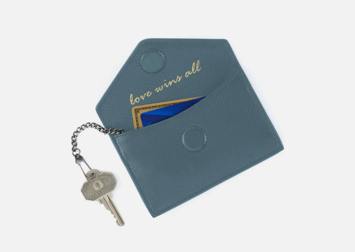 A new card case with an envelope-style foldover flap, Goldie is designed to carry your most-used cards, cash, and ID.

SEE MORE DETAILS
What It Is

An envelope-style card case that reminds you “love wins all.”