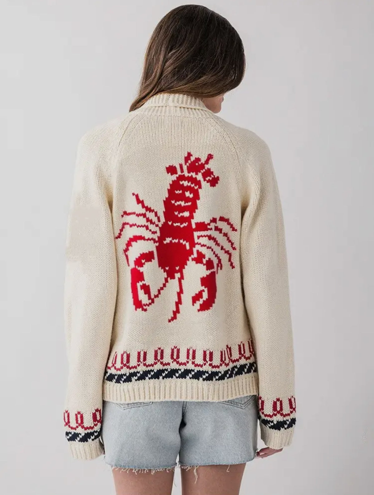 This cozy knit cardigan gives the effortless coastal energy and is perfect for cooler days, chilly nights by the bonfire and endless summer vibes. 

Cream sweater with large red lobster on back and red and blue knit around the waist and wrists. 