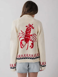 This cozy knit cardigan gives the effortless coastal energy and is perfect for cooler days, chilly nights by the bonfire and endless summer vibes. 

Cream sweater with large red lobster on back and red and blue knit around the waist and wrists. 