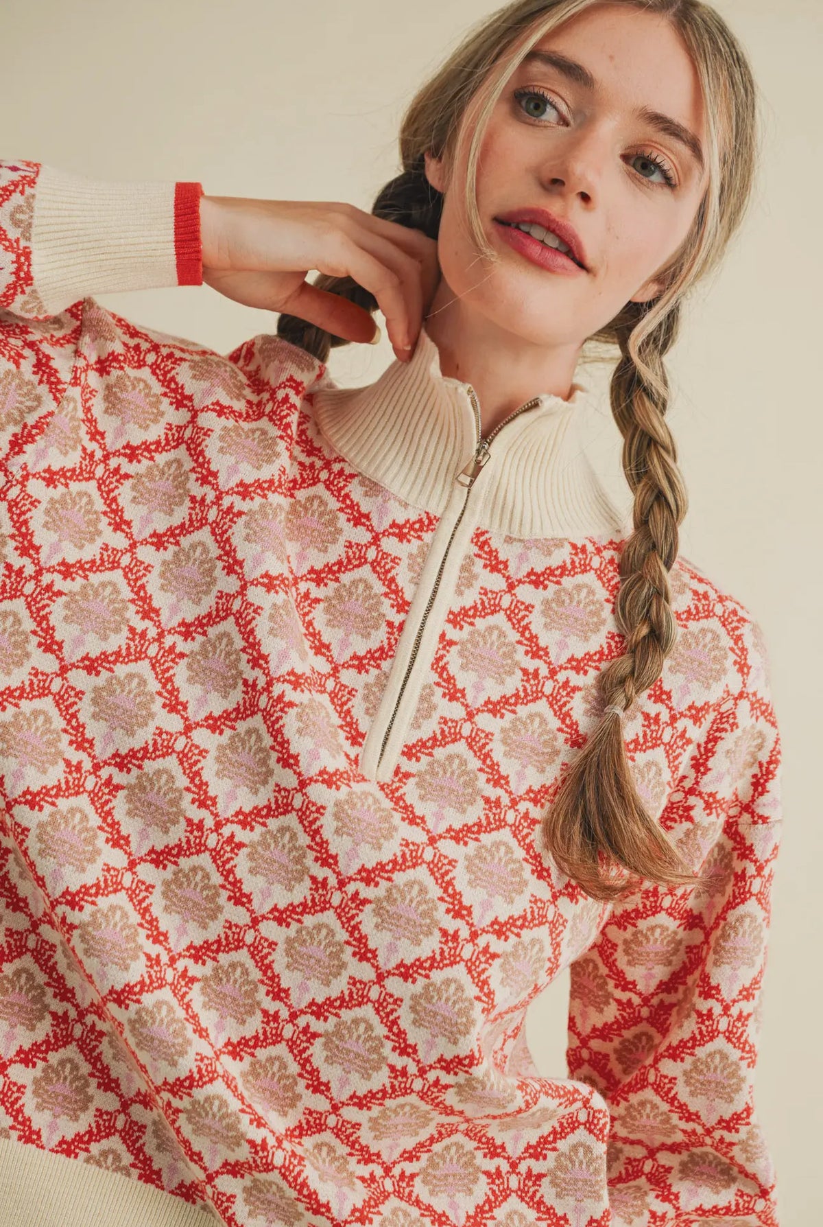 Warm reds and creams make up this sweater. Quarter zip neck
