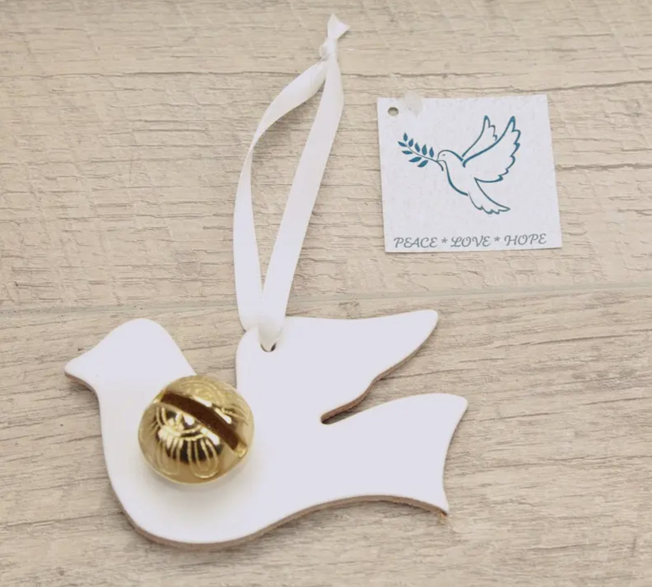 These lovely Dove keepsake bells make a perfect small gift. The Dove has a white ribbon and can be hung up in a special place as a reminder of the time shared with you. Doves are a sign of Peace, Love and Hope. They are about 4" wide and 3" tall. These are made in white leather and your choice of a brass or silver (Nickle plated) bell. 