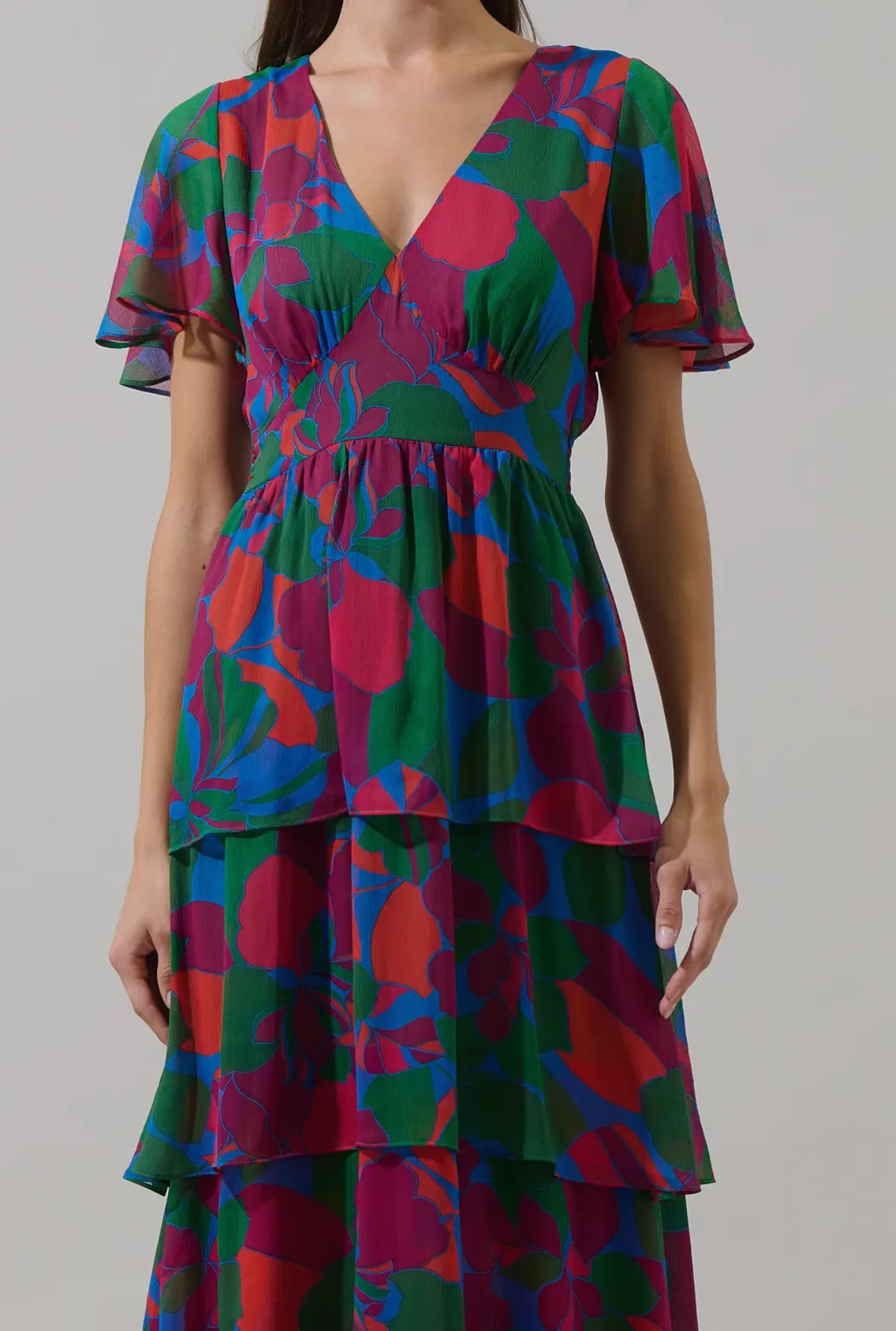 Keep it cute and pretty in the Kaeli Floral Amabel Tiered Maxi Dress. This floral-patterned maxi features a deep v-neck, short sleeves, and a tiered design with a smocked back for a flattering silhouette. Style it with block heels and a delicate clutch for a polished finish.

- Maxi
- Floral
- Deep V-neck
- Tiered
- Color: Magenta Blue Green

Size + Fit
- Model is 5'9" and wearing size XS
- Measurements taken from size S
- Chest: 19"
- Length: 58 1/4"

Fabric

Self: 100% Polyester, Lining: 97% Polyester 3% 