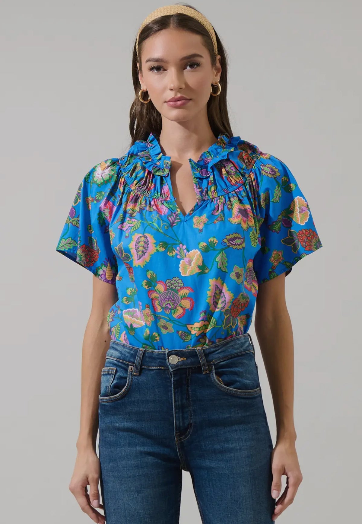 Sweet and stylish, this floral top is your new go-to for sunny days. This short sleeve top has a split neck, relaxed fit, with a ruffle detail to give you a chic look. Throw on some trousers and heels for dressed up look or keep it casual with sneakers and jeans.

- Split neck
- Short sleeve
- Floral
- Ruffle details
- Color: Blue Pink

Size + Fit
- Model is 5'9" and wearing size XS
- Measurements taken from size S
- Chest: 21"
- Length: 24 1/2"

Fabric

Self: 100% Cotton