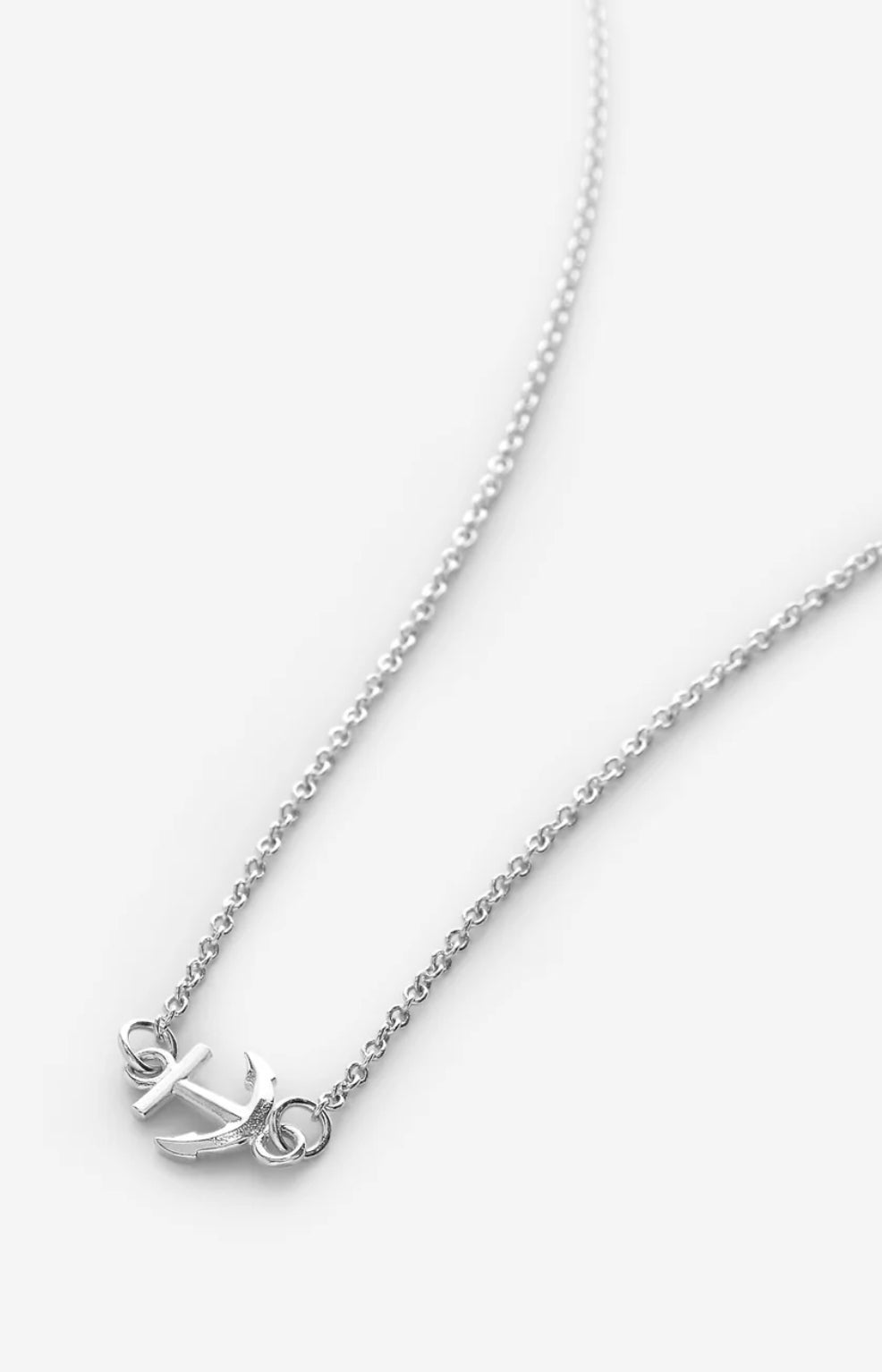 Silver necklace shown laying on white background 