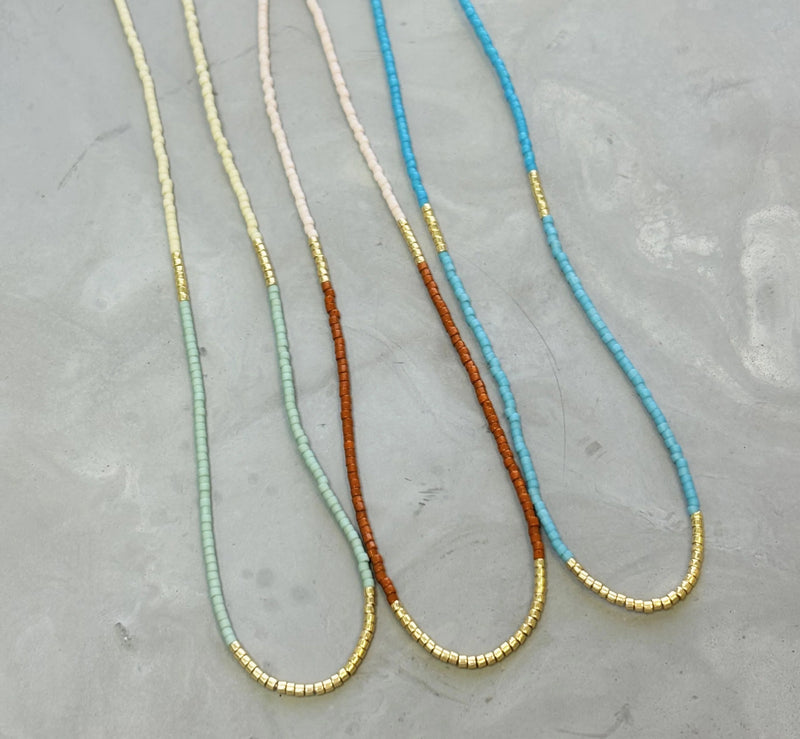 Our  necklace is handcrafted with a touch of gold in a minimalist style.   

•Seed beads in your choice of color combination 
•Hand strung in a modern pattern
•14kt Gold-Filled beads & spring clasp

•16 or 18 inch in length with an optional 2 inch extender 