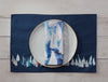 Showing dark blue side with a plate and matching napkins. 