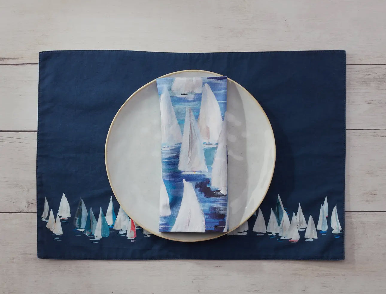 Showing dark blue side with a plate and matching napkins. 