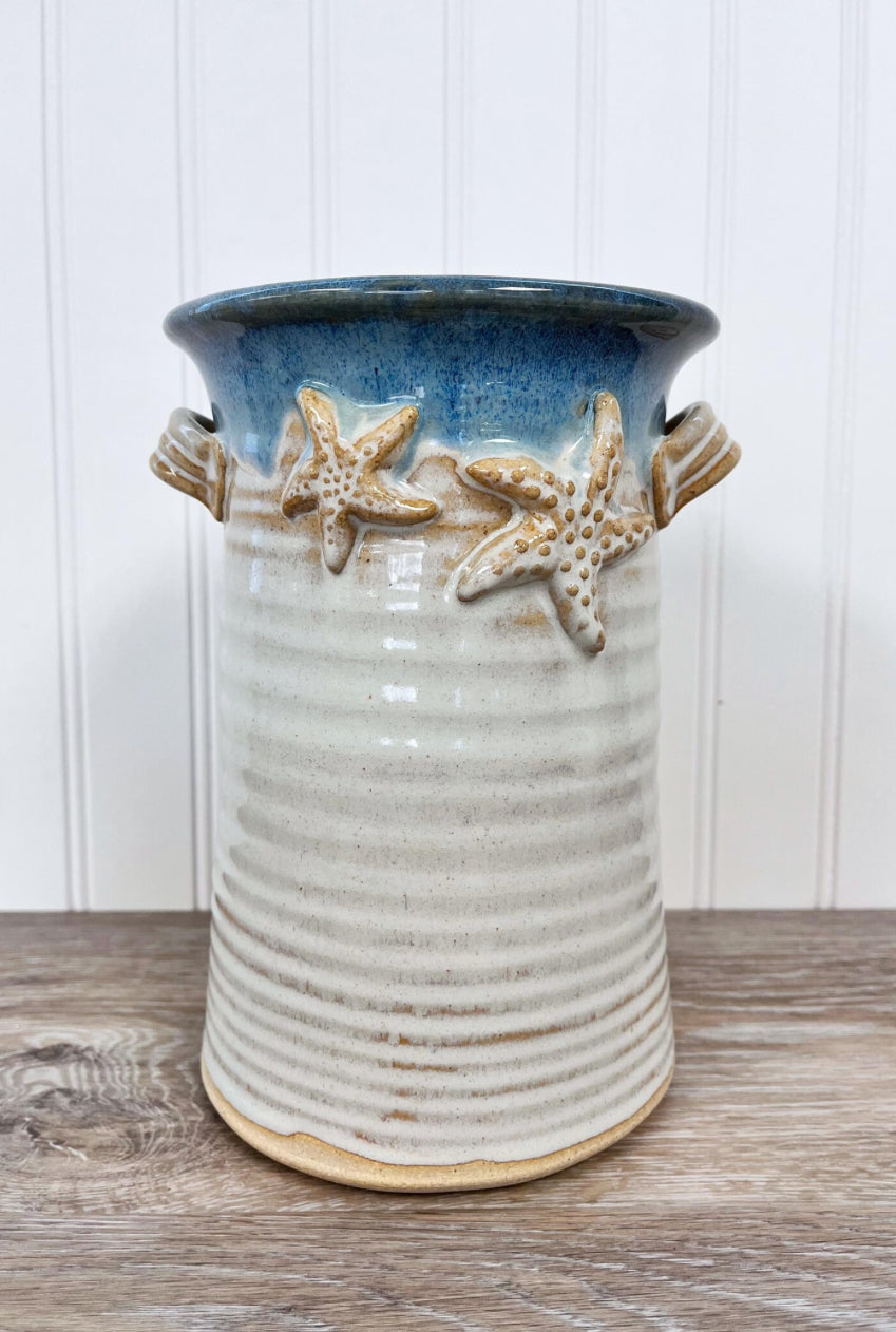 Organize your kitchen or dining space with our Wine Bottle Holder / Utensil Holder, designed to elegantly store both utensils and wine accessories. 
The Dimensions of this item are approximately 6x6x9.

Each piece of pottery is crafted with love. There may be slight variations in sizes and glazes making them truly one-of-a-kind.