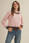 The warm pink and brown hies in this weather are perfect for getting cozy this winter. It also makes a great transition piece. The round neckline in contrasting colors adds to the details of this sweater.  