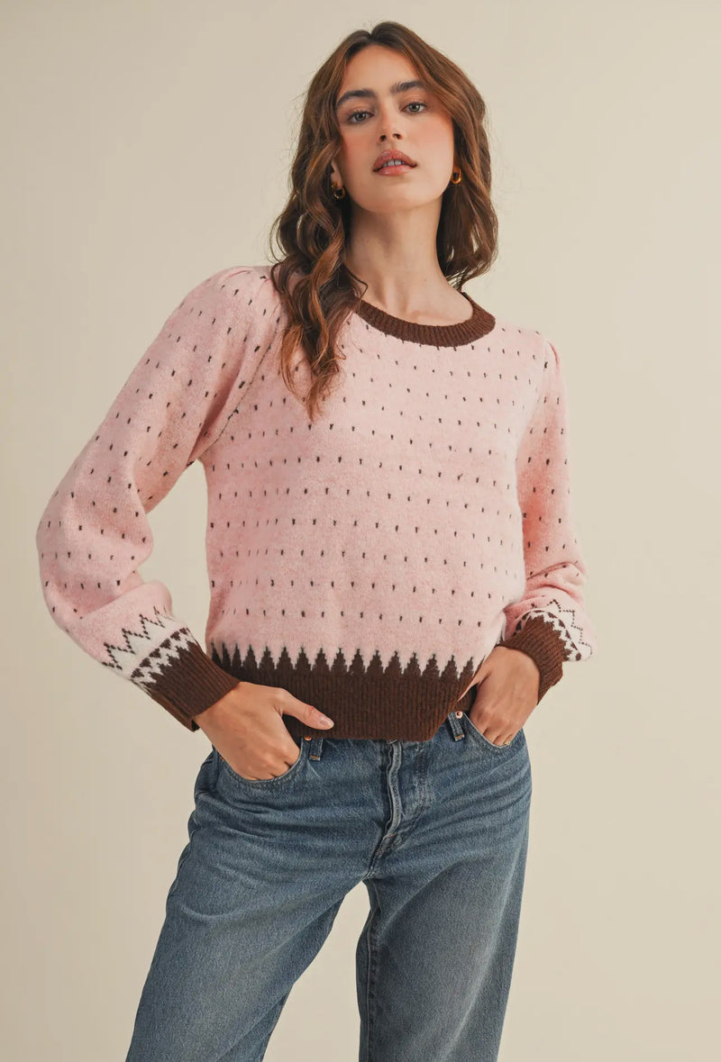 The warm pink and brown hies in this weather are perfect for getting cozy this winter. It also makes a great transition piece. The round neckline in contrasting colors adds to the details of this sweater.  
