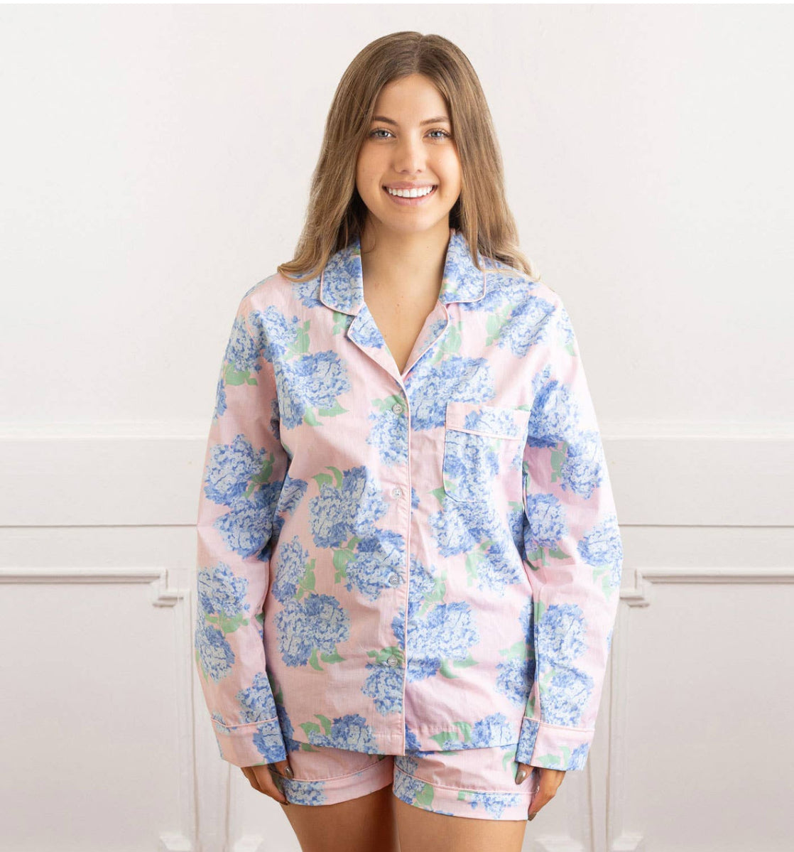 leep in style with our Hydrangea Pink Pajama Set. Crafted from 100% woven cotton, this set is designed to keep you comfortable so you can make the most of your rest. This elegant short set features a button-front long sleeve top & drawstring waist shorts with the classic allure of a blue hydrangea print, making it the perfect choice for any occasion. Slip into your own piece of elegance with our Hydrangea Pink Pajama Set today! 